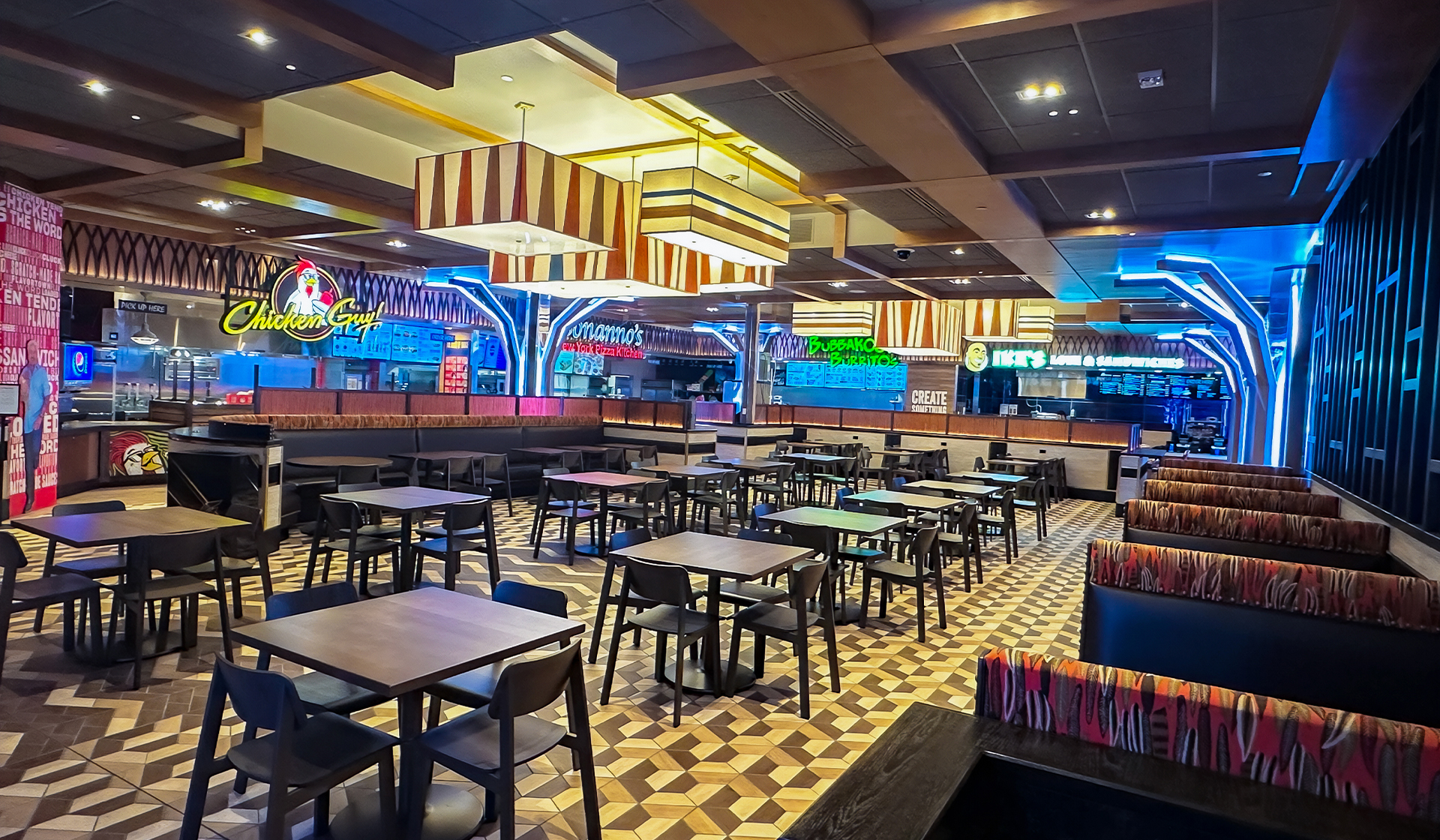 The layout of restaurant with vibrant lights and many chairs and tables to sit at.